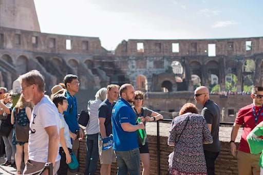 tour guide with his group admiring the colosseum