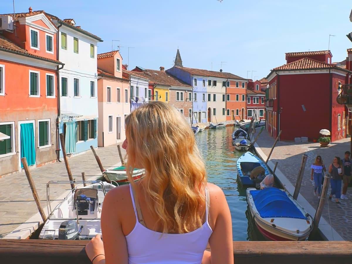 Tourist admiring the beautiful colorful houses of Burano in Italy